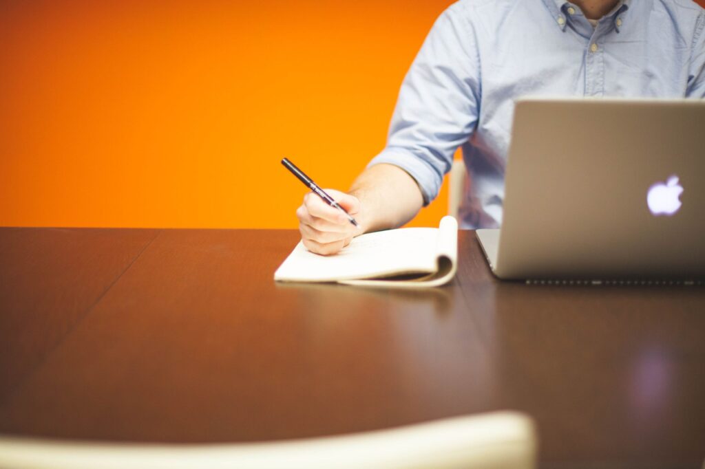 B2B professional writing a LinkedIn post on a laptop for a Thought Leader Ads campaign
