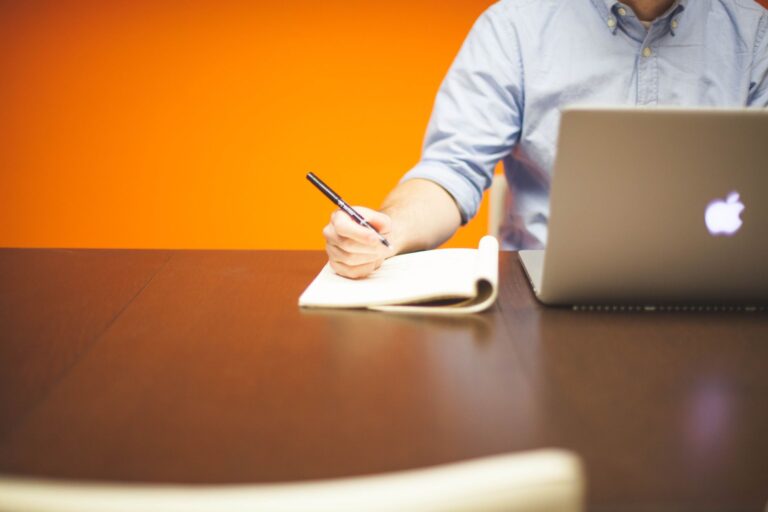 B2B professional writing a LinkedIn post on a laptop for a Thought Leader Ads campaign