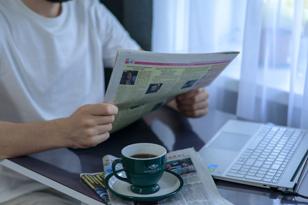 Laptop, newspaper and coffee on a desk for the weekly digital marketing news roundup