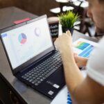 Marketer reviewing website conversion rate charts on a laptop
