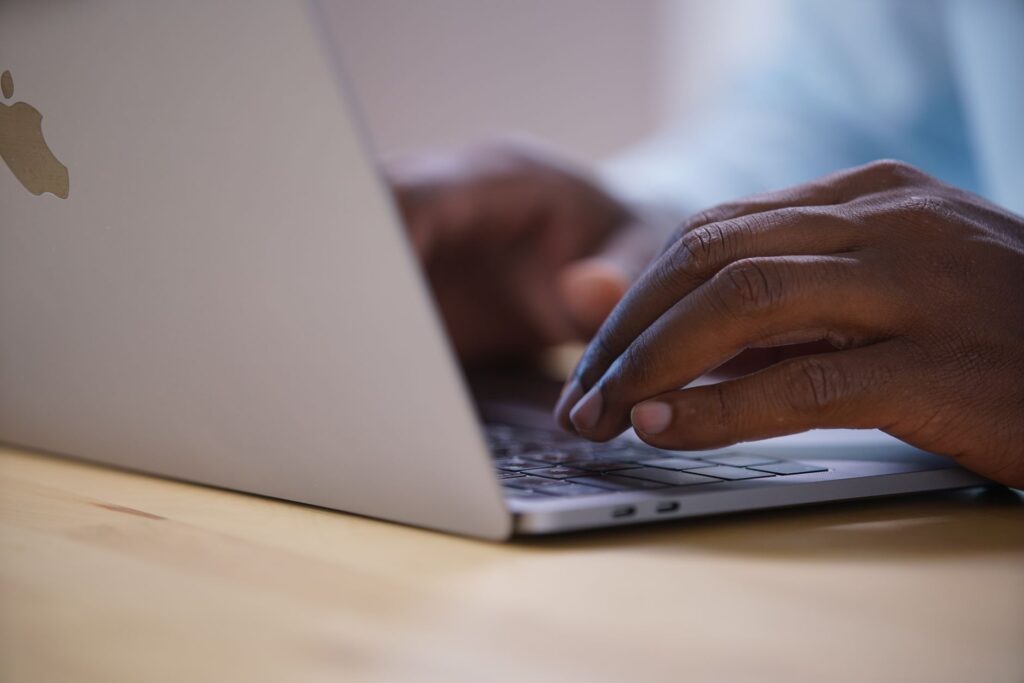 Marketer typing a question into an AI search bar on a laptop, illustrating AI search optimization
