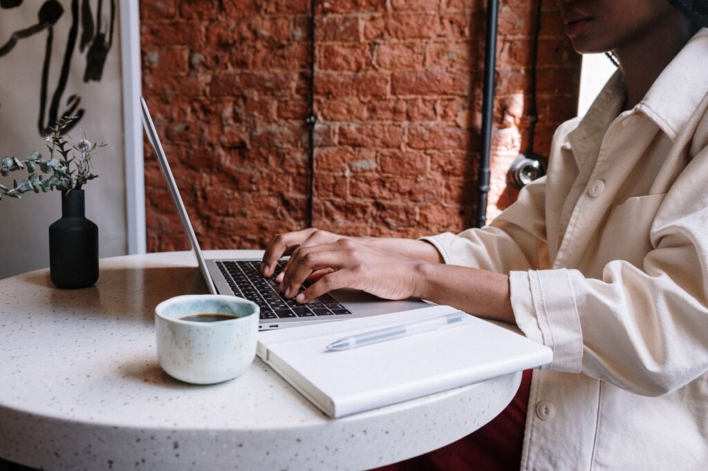 Marketer writing a blog post and planning a content marketing calendar on a laptop