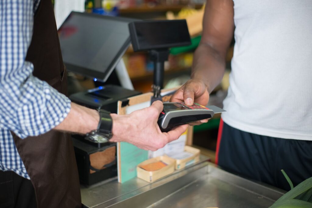 Returning customer paying at a store counter, representing Google Ads retention modes for loyal and lapsed buyers
